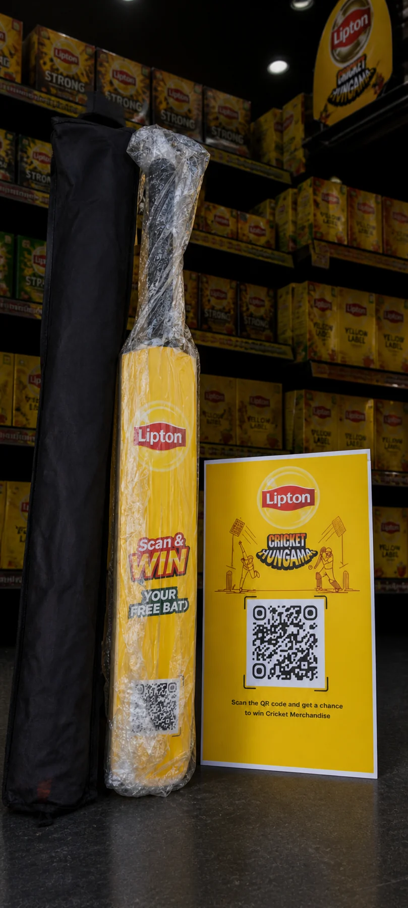 A Lipton brand ambassador with the campaign standee and bat at an Imtiaz entrance