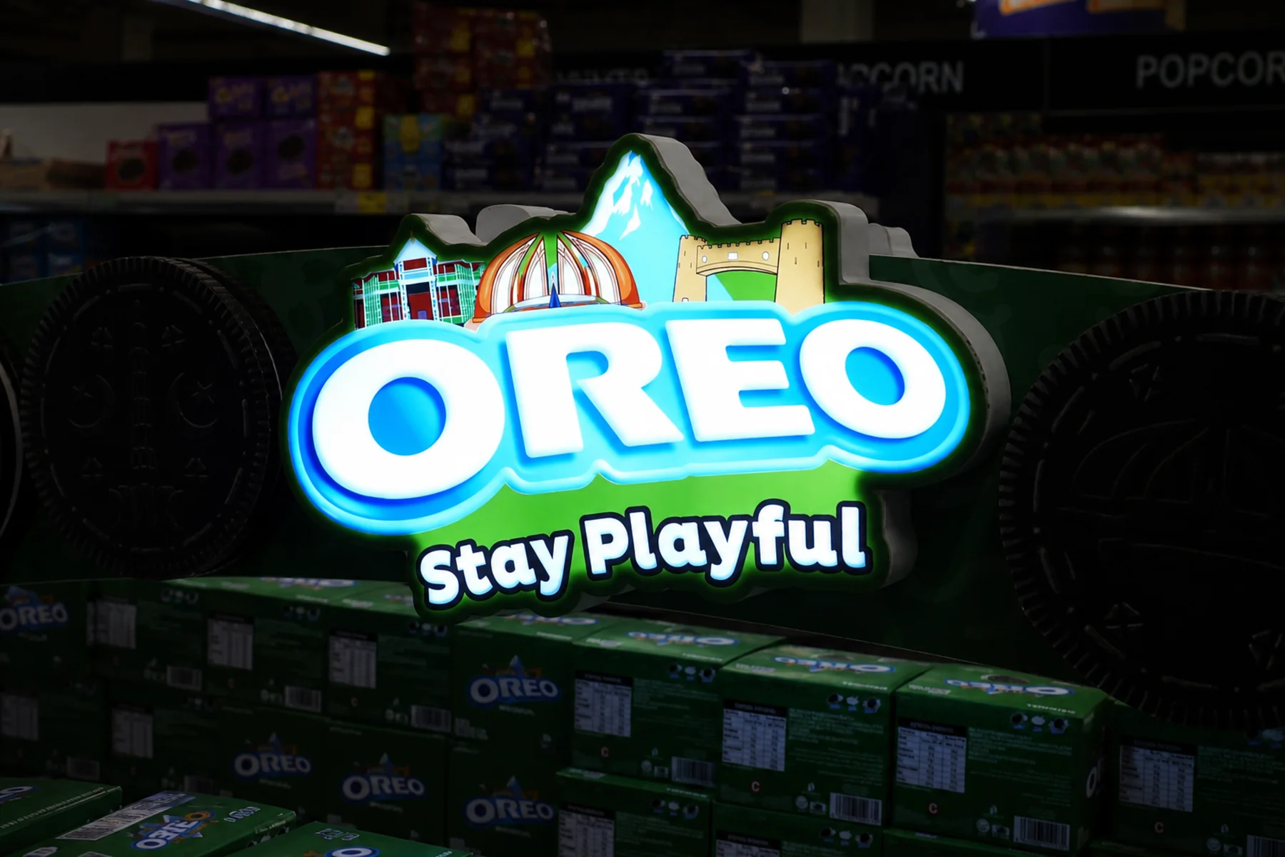 Illuminated Oreo Stay Playful sign at the crown of the arch