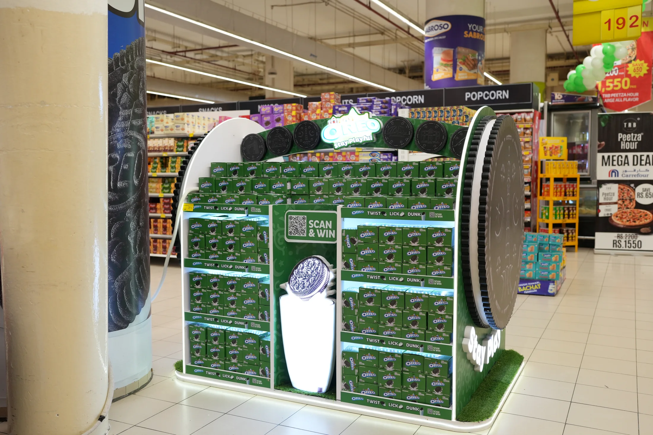 Front view of the fully stocked Oreo island with the scan-and-win panel centred between the tiers