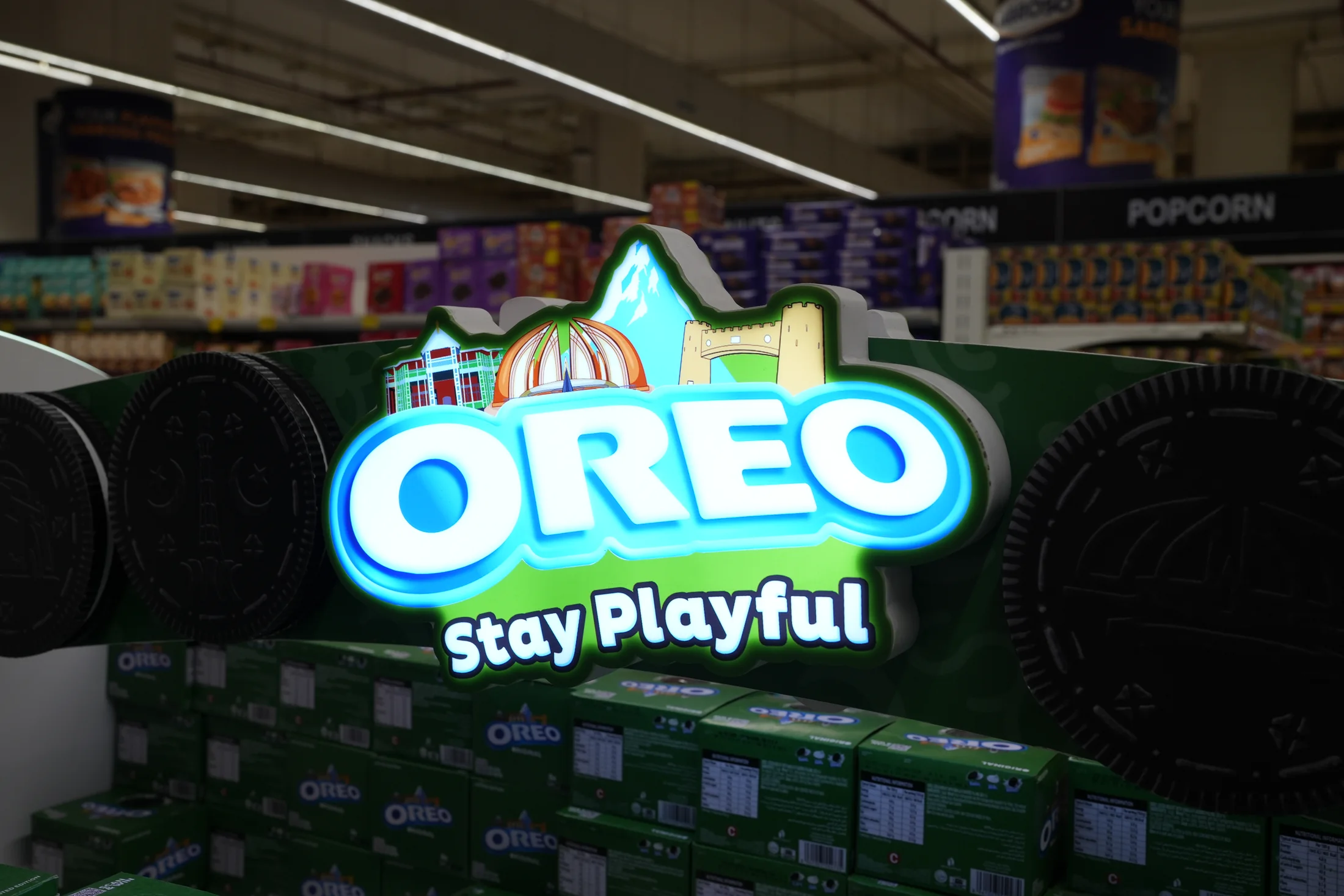 Close view of the illuminated Oreo Stay Playful header and biscuit discs
