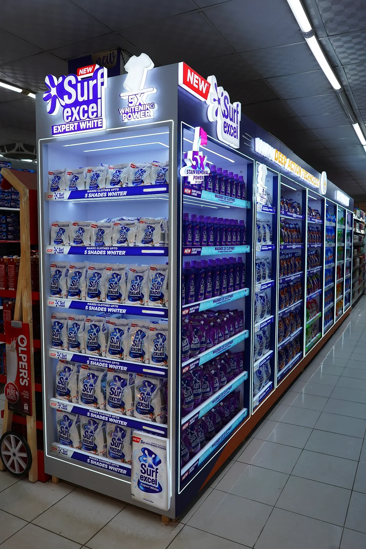 Illuminated Surf Excel end standing out in an unlit aisle